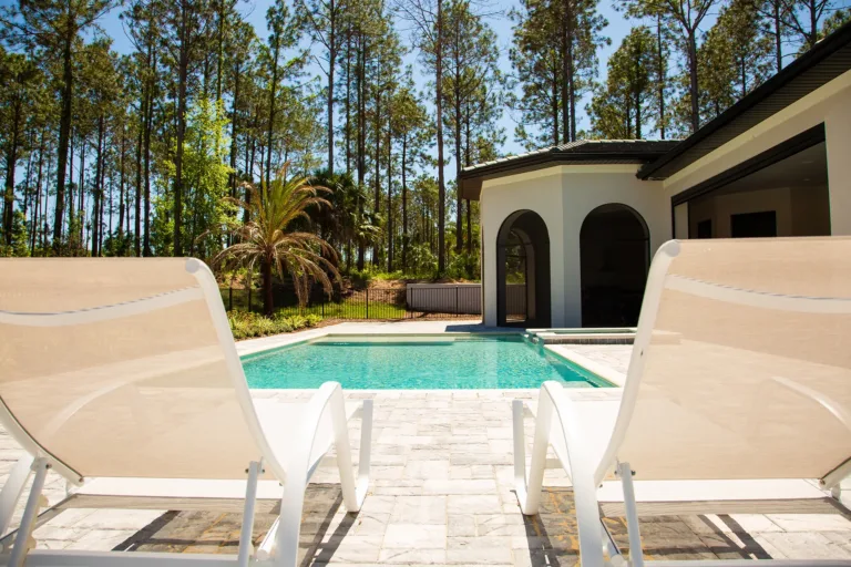 Pool and loungers framed by tall pines