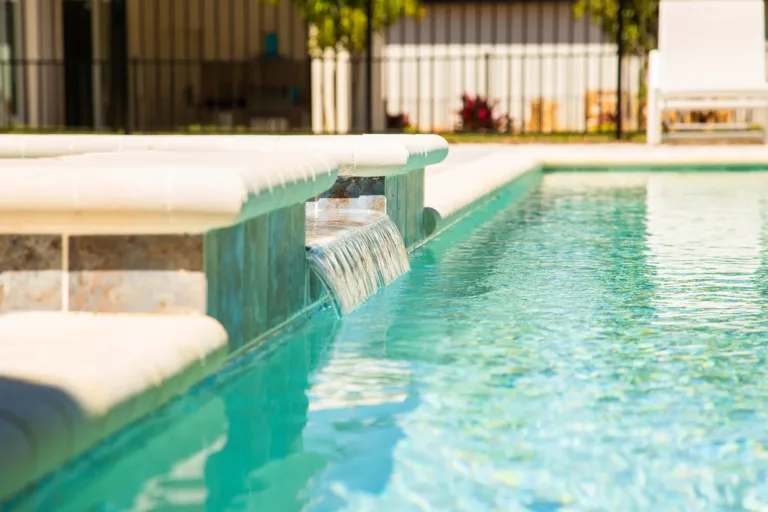 Raised spa wall with water spillway into a pool