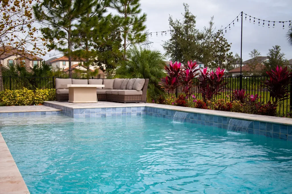 Custom pool with a raised wall, fire feature and outdoor lounge seating